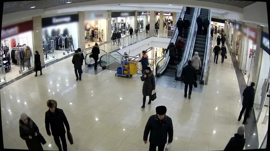 Атриум торгового центра с эскалаторами и покупателями